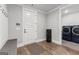 A mud room includes a bench, coat hooks, laundry and a door to the outside at 180 Lapis Lake Pt, Fayetteville, GA 30215