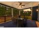 Inviting porch with comfortable seating, ceiling fan, and scenic wooded view, perfect for relaxation and outdoor enjoyment at 180 Lapis Lake Pt, Fayetteville, GA 30215