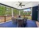 Covered porch featuring an outdoor dining area, ceiling fan, and wooded views at 180 Lapis Lake Pt, Fayetteville, GA 30215
