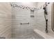 Close-up of shower showcasing a bench seat, gray tile, and pebble accents, creating a spa-like experience at 180 Lapis Lake Pt, Fayetteville, GA 30215