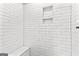 Close-up of a shower stall featuring white subway tile, a built-in niche, and a bench at 180 Lapis Lake Pt, Fayetteville, GA 30215