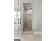 Modern shower featuring gray tile, a rainfall shower head, and pebble accents, creating a spa-like experience at 180 Lapis Lake Pt, Fayetteville, GA 30215