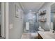 Bathroom with a modern glass-enclosed shower, neutral tiling, and a storage unit with decorative accents at 75 Barber Rd, Carrollton, GA 30116