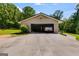 Spacious detached garage with a concrete driveway surrounded by a lush green lawn and mature trees at 75 Barber Rd, Carrollton, GA 30116