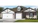Charming single-story home with brick and siding, featuring a three-car garage and well-manicured lawn at 100 Grande Bishop Dr, Fairburn, GA 30213
