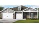 Charming single-story home with brick and siding, featuring a three-car garage and well-manicured lawn at 100 Grande Bishop Dr, Fairburn, GA 30213
