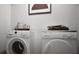 Laundry room with modern front load washer and dryer and decor at 100 Grande Bishop Dr, Fairburn, GA 30213