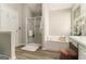 Bright bathroom featuring a shower, soaking tub, wood-look floors, and a vanity with white cabinets at 1444 Gates Se Cir, Atlanta, GA 30316