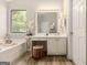 Bright bathroom featuring a vanity with white cabinets, a large mirror, and wood-look floors at 1444 Gates Se Cir, Atlanta, GA 30316