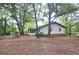 View of the back of the house with siding, brick foundation, and lots of trees at 1590 Colonial South Sw Dr, Conyers, GA 30094