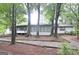 Backyard view of the house with mature trees and a pebble and wood path at 1590 Colonial South Sw Dr, Conyers, GA 30094