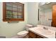 Well-lit bathroom showcasing a sink vanity, toilet, and a window with natural light and safety grab bar at 1590 Colonial South Sw Dr, Conyers, GA 30094