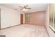 Spacious bedroom featuring neutral carpet, a ceiling fan and plenty of natural light from the window at 1590 Colonial South Sw Dr, Conyers, GA 30094