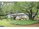 Single-story home with lush landscaping, mature trees, and a well-manicured lawn at 1590 Colonial South Sw Dr, Conyers, GA 30094