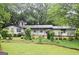Charming single-story home with a well-maintained front yard and mature trees at 1590 Colonial South Sw Dr, Conyers, GA 30094