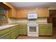 Traditional kitchen featuring two-tone cabinetry, white appliances, and wood-look flooring at 1590 Colonial South Sw Dr, Conyers, GA 30094