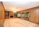 Spacious living room with wood paneling, brick fireplace, and sliding glass doors at 1590 Colonial South Sw Dr, Conyers, GA 30094