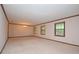 Large living room with neutral-colored walls, carpet, and multiple windows at 1590 Colonial South Sw Dr, Conyers, GA 30094