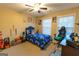 Comfortable bedroom with natural light, a ceiling fan, and a playful, gamer-themed décor at 6089 Indian Wood Cir, Mableton, GA 30126