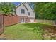 Large backyard featuring lush green grass, a brick wall, and a fenced area at 305 Postwood Dr, Fayetteville, GA 30215