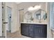 Charming bathroom with dual sinks, a large dark vanity, hexagon mirrors and modern lighting at 305 Postwood Dr, Fayetteville, GA 30215