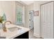 Well-lit bathroom featuring a marble countertop sink, a window, and modern fixtures at 305 Postwood Dr, Fayetteville, GA 30215