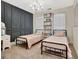Cozy bedroom with matching twin beds, a chandelier, dark accent wall and a shelving unit at 305 Postwood Dr, Fayetteville, GA 30215