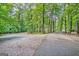 Gravel driveway leading to treed land, and possible building site at 305 Postwood Dr, Fayetteville, GA 30215