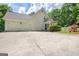 Large driveway with attached garage and well-maintained landscaping at 305 Postwood Dr, Fayetteville, GA 30215