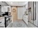 Modern kitchen features white cabinets, stainless steel appliances, and rustic door at 305 Postwood Dr, Fayetteville, GA 30215
