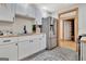 Modern kitchen features white cabinets, stainless steel fridge, and view to another room at 305 Postwood Dr, Fayetteville, GA 30215