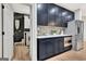 Kitchenette area with black cabinets and stainless appliances, laundry room visible in background at 305 Postwood Dr, Fayetteville, GA 30215