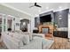 Open-concept living room with a brick fireplace, stylish decor, and seamless flow to the adjacent dining area at 305 Postwood Dr, Fayetteville, GA 30215