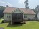 Lovely back exterior featuring a screened-in porch and a well-manicured green lawn for outdoor enjoyment and relaxation at 650 Flippen Rd, Stockbridge, GA 30281