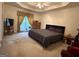Spacious main bedroom featuring a tray ceiling, plush carpet, and ample natural light at 650 Flippen Rd, Stockbridge, GA 30281