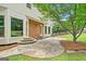Charming backyard patio with stone pavers, leading to the house with brick accents and multiple windows at 2010 Pearwood Path, Roswell, GA 30076