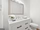 Well-lit half bathroom with a white vanity, modern faucet, decorative mirror, and tiled backsplash at 2010 Pearwood Path, Roswell, GA 30076