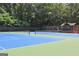 Well-maintained community tennis courts with blue and green surfaces, surrounded by trees and a shaded gazebo at 2010 Pearwood Path, Roswell, GA 30076