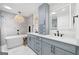 Modern bathroom with a soaking tub, gray cabinets, a light fixture and double vanity sinks at 2885 Laurel Green Ct, Roswell, GA 30076
