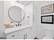 Well-lit bathroom showcasing white vanity, matte black faucet, round mirror, and ample storage at 2885 Laurel Green Ct, Roswell, GA 30076