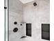 Close up of stylish walk-in shower with gray tile, black fixtures, and built-in shelving at 2885 Laurel Green Ct, Roswell, GA 30076