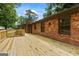 Brick home featuring a spacious wooden deck and a brick chimney at 1124 Ponderosa Park Dr, Forest Park, GA 30297