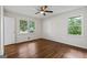 Bright bedroom featuring hardwood floors, a ceiling fan, and natural light from multiple windows at 1124 Ponderosa Park Dr, Forest Park, GA 30297