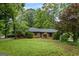 Brick home with well-maintained landscaping, mature trees, and lush green lawn at 1124 Ponderosa Park Dr, Forest Park, GA 30297
