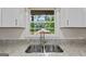 Close up of kitchen sink and window showing white cabinets and granite countertops at 1124 Ponderosa Park Dr, Forest Park, GA 30297