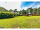 Sprawling backyard with lush grass, mature trees, and a wooden deck and fence at 130 Laurel Lake Rd, Tyrone, GA 30290