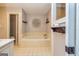 Inviting bathroom with a soaking tub, neutral tile, and decorative shelving at 130 Laurel Lake Rd, Tyrone, GA 30290