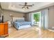 Spacious main bedroom with tray ceiling, wood floors, and large window letting in natural light at 130 Laurel Lake Rd, Tyrone, GA 30290