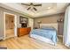 Comfortable main bedroom featuring a tray ceiling, wood floors, and soft, natural light at 130 Laurel Lake Rd, Tyrone, GA 30290