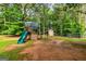 Backyard playground set featuring a slide, climbing wall, swings, and playhouse at 130 Laurel Lake Rd, Tyrone, GA 30290